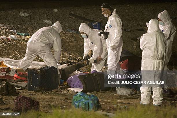 Forensic personnel gather the bodies of victims of a bus crash in Anahuac, Nuevo Leon state on February 14, 2015. At least 16 people were killed and...