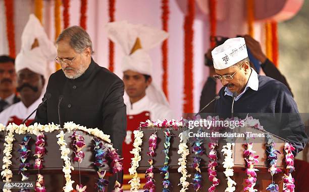 Aam Aadmi Party convener Arvind Kejriwal takes the oath by Delhi LG Najeeb Jung during his swearing-in ceremony as the chief minister of Delhi at the...