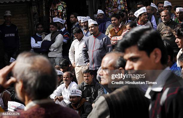 People look at the screens installed during the swearing-in ceremony of AAP leader Arvind Kejriwal at the Ramlila Ground on February 14, 2015 in New...