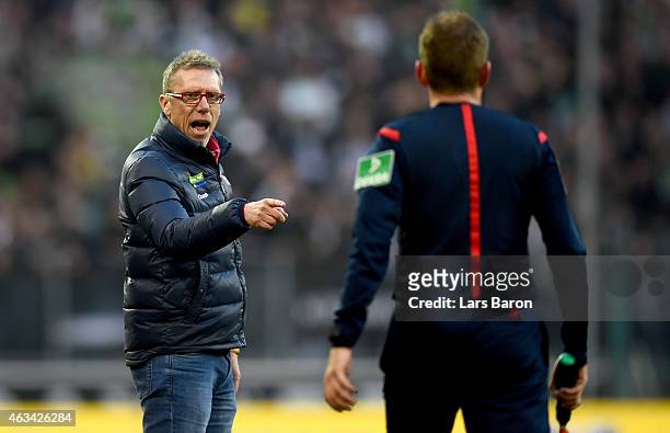 Head coach Peter Stoeger discusses with assistant referee MArkus Haecker during the Bundesliga match between Borussia Moenchengladbach and 1. FC...