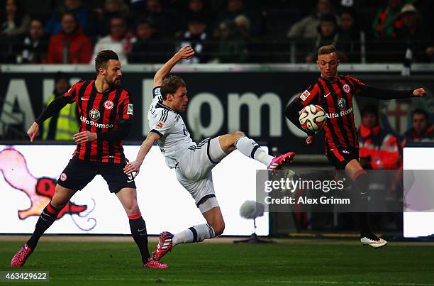 Benedikt Hoewedes of Schalke is challenged by Haris Seferovic and Sonny Kittel of Frankfurt during the Bundesliga match between Eintracht Frankfurt...