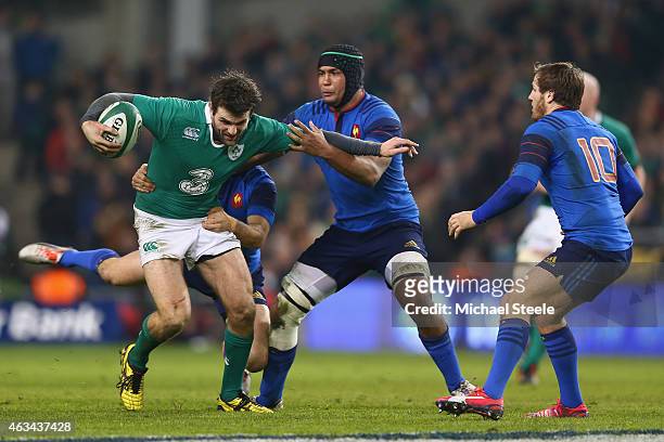 Jared Payne of Ireland is held up by Morgan Parra and Thierry Dusautoir of France during the RBS Six Nations match between Ireland and France at the...