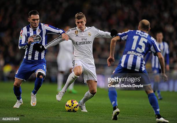 Toni Kroos of Real Madrid is tackled by Lucas Perez of RC Deportivo La Coruna during the La Liga match between Real Madrid CF and RC Deportivo La...