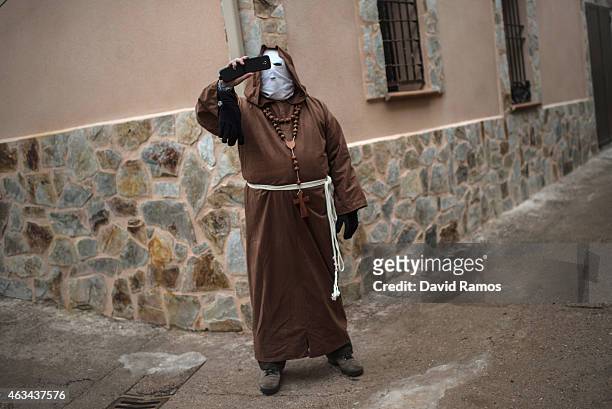 Man dressed up as a monk takes pictures during a carnival festival on February 14, 2015 in Luzon, Spain. Every year Luzon hosts one of the...