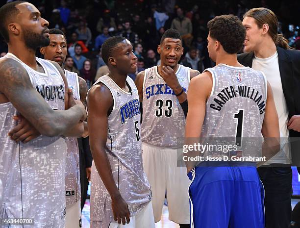 Robert Covington of the Philadelphia 76ers and Victor Oladipo of the Orlando Magic talk things over with fellow teammates during the 2015 NBA...