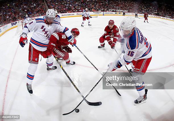 Kevin Klein and Derick Brassard of the New York Rangers control the puck under pressure from Martin Erat and Antoine Vermette of the Arizona Coyotes...