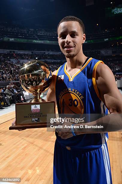 Stephen Curry of the Golden State Warriors poses for photos with his trophy after winning the Foot Locker Three Point Contest on State Farm All-Star...