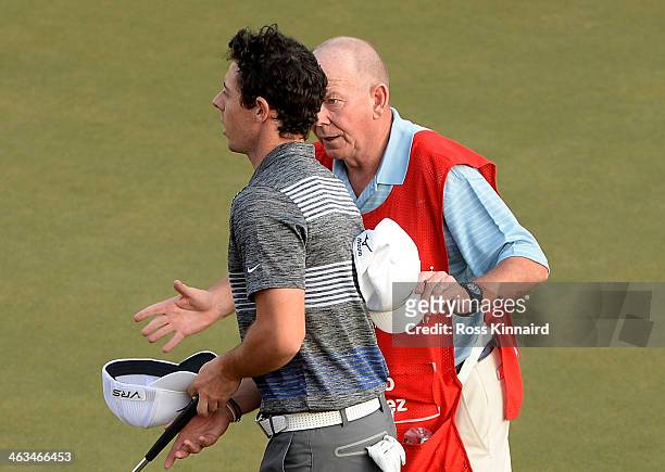 Rory McIlroy of Northern Ireland taliking to caddie Dave Renwick on the 18th green after he was informed of a possible rules issue during the third...