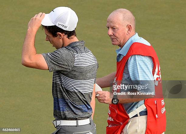 Rory McIlroy of Northern Ireland taliking to caddie Dave Renwick on the 18th green after he was informed of a possible rules issue during the third...