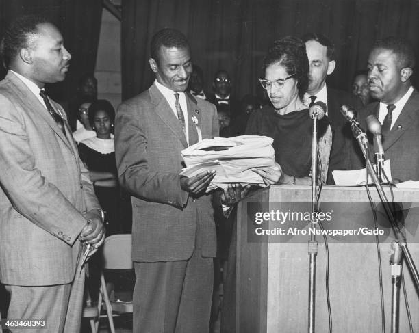 Civil rights activist Fred Shuttlesworth , second from left, receives a Southern Christian Leadership Conference citation from Rosa Parks as Dr....