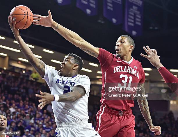 Guard Marcus Foster of the Kansas State Wildcats drives to the basket past forward D.J. Bennett of the Oklahoma Sooners during the second half on...