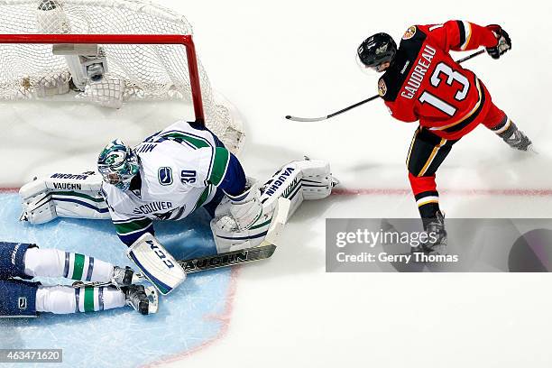 Johnny Gaudreau of the Calgary Flames shoots the puck against Ryan Miller of the Vancouver Canucks at Scotiabank Saddledome on February 14, 2015 in...