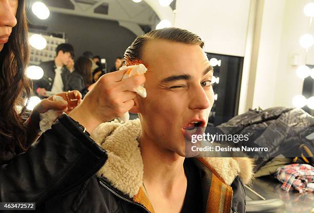 Model prepares backstage at the Robert Geller fashion show during Mercedes-Benz Fashion Week Fall 2015 at Pier 59 on February 14, 2015 in New York...