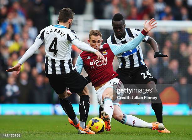 Jack Collison of West Ham United is challenged by Yohan Cabaye and Cheick Tiote of Newcastle United during the Barclays Premier League match between...