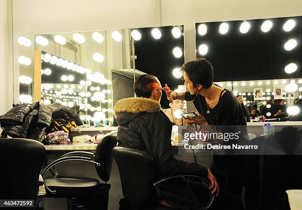 Model prepares backstage at the Robert Geller fashion show during Mercedes-Benz Fashion Week Fall 2015 at Pier 59 on February 14, 2015 in New York...