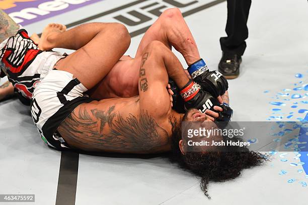 Benson Henderson attempts to submit Brandon Thatch with a rear naked choke in their welterweight fight during the UFC Fight Night event inside...