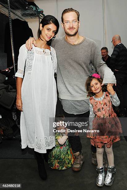 Designer Robert Geller poses with his wife designer Ana Beatriz Leraro and their daughters backstage at the Robert Geller fashion show during...