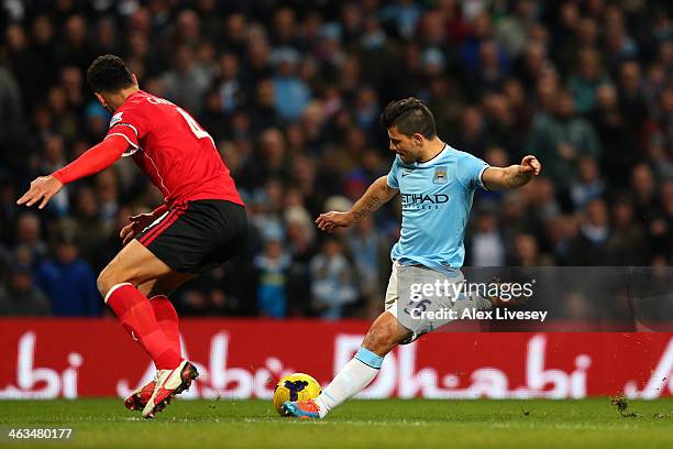 Sergio Aguero of Manchester City shoots past Steven Caulker of Cardiff to score his team's fourth goal during the Barclays Premier League match...