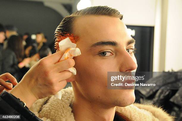 Model prepares backstage at the Robert Geller fashion show during Mercedes-Benz Fashion Week Fall 2015 at Pier 59 on February 14, 2015 in New York...