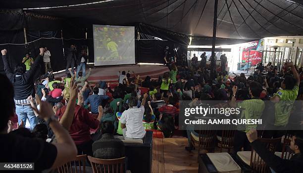 Pakistani cricket fans react as they watch the live broadcast of the Cricket World Cup match between Pakistan and India on a viewing screen in...