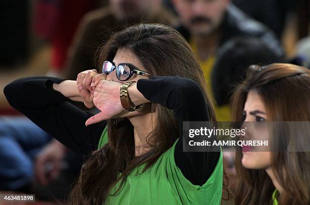 Pakistani cricket fans react as they watch the live broadcast of the Cricket World Cup match between Pakistan and India on a viewing screen in...