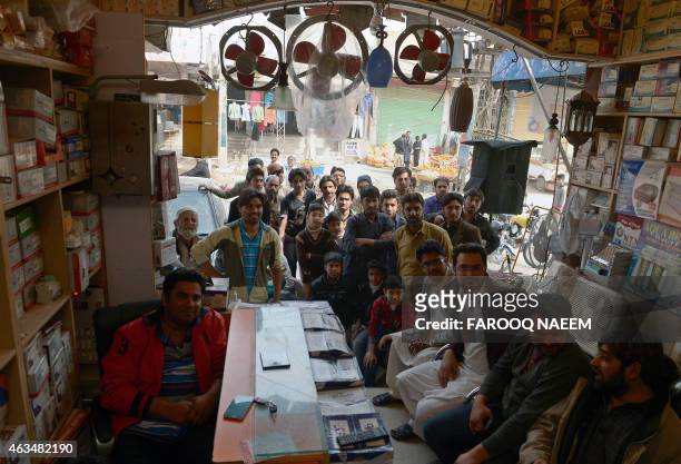 Pakistani shopkeepers and residents watch the live broadcast of the Cricket World Cup match between Pakistan and Indian at a market in Rawalpindi on...