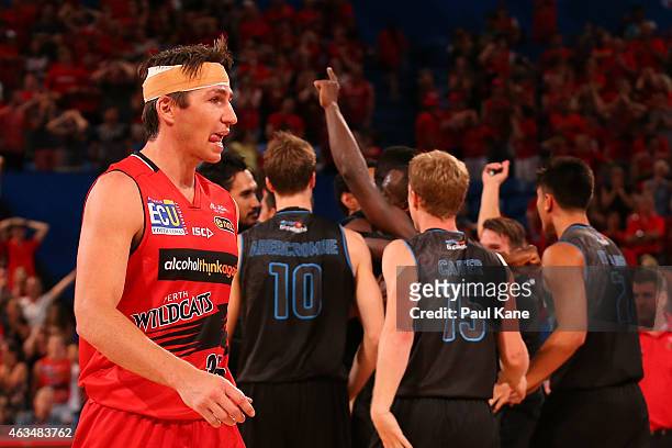 Damian Martin of the Wildcats walks from the court as the Breakers celebrate after a three point shot by Cedric Jackson to win the game in double...