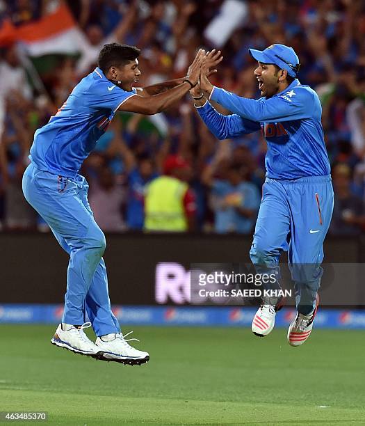 India's paceman Umesh Yadav celebrates his second wicket of Pakistan's Sohaib Maqsood with teammate Rohit Sharma during the Pool B 2015 Cricket World...