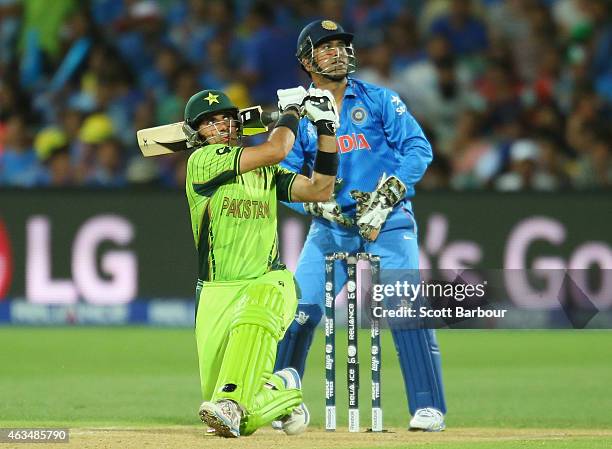 Misbah-ul-Haq of Pakistan hits a boundary as wicketkeeper MS Dhoni of India looks on during the 2015 ICC Cricket World Cup match between India and...