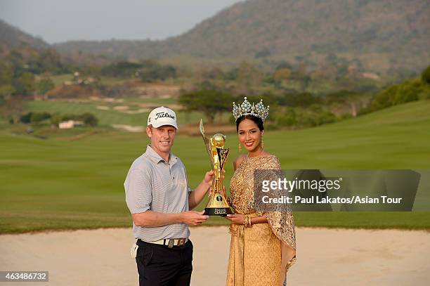 Andrew Dodt of Australia pictured with the winner's trophy and Miss Thailand World - 2014- Nonthawan Thongleng during round four of the Thailand...