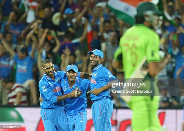 Umesh Yadav of India celebrates with Shikhar Dhawan and Ajinkya Rahane after taking a catch to dismiss Sohail Khan of Pakistan and win the match...