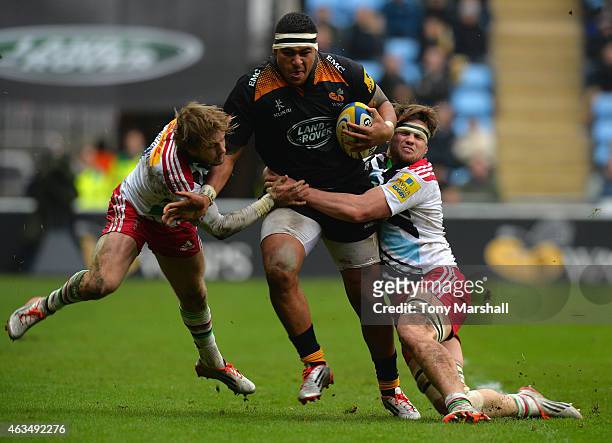 Nathan Hughes of Wasps is tackled by Charlie Walker and Jack Clifford of Harlequins during the Aviva Premiership match between Wasps and Harlequins...