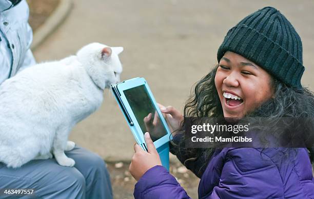 girl is taking picture on her tablet - cat laughing - fotografias e filmes do acervo