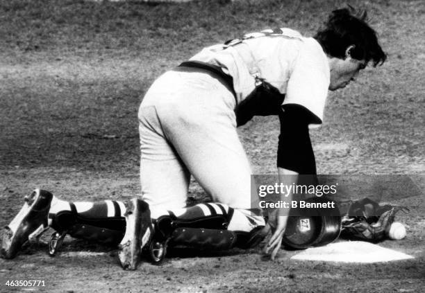 Catcher Carlton Fisk of the Boston Red Sox is down on his hands and knees in pain after being hit by a fout tip during an MLB game against the New...