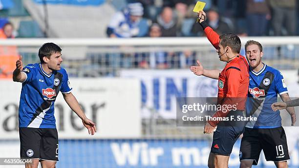 Referee Robert Hartmann show the yellow card to Florian Dick of Bielefeld while Felix Burmeister of Bielefeld complains during the Third League match...