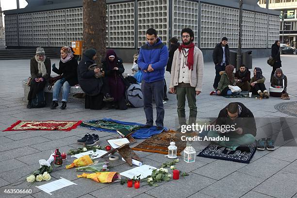 Demonstrators read holy Quran and perform prayer as they gather at Breitscheidplatz square to protest against the Chapel Hill shooting, in Berlin,...