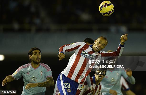 Atletico Madrid's Brazilian defender Joa Miranda de Souza heads the basll next to Celta's Argentinian forward Joaquin Larrivey during the Spanish...