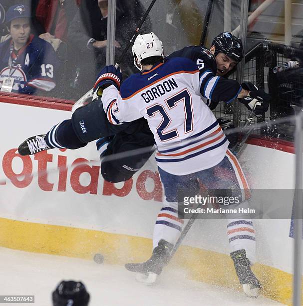 Boyd Gordon of the Edmonton Oilers and Mark Stuart of the Winnipeg Jets collide along the boards in first period action in an NHL game at the MTS...