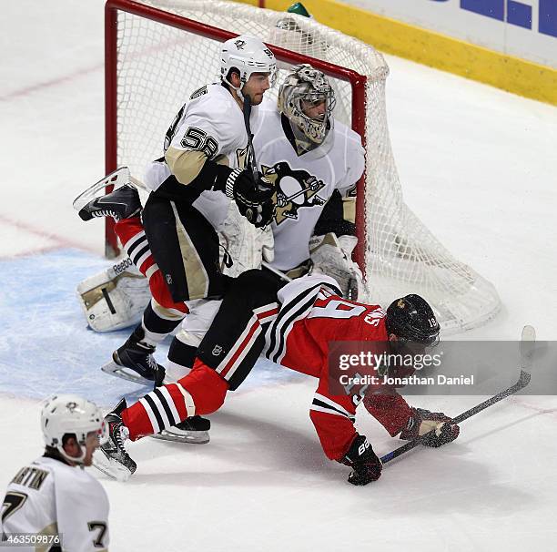 Jonathan Toews of the Chicago Blackhawks is knocked to the ice by Kris Letang of the Pittsburgh Penguins as Marc-Andre Fleury follows the puck at the...