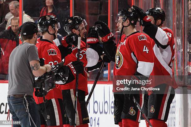 Chris Phillips of the Ottawa Senators high-fives teammate Erik Karlsson following their win against the Winnipeg Jets during an NHL game at Canadian...
