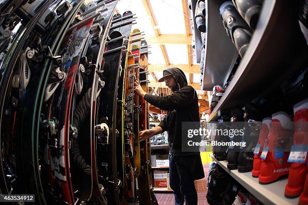 An employee arranges ski in this photograph taken with a fish-eye lens inside a rental ski shop at the Niseko Hanazono resort, operated by Nihon...