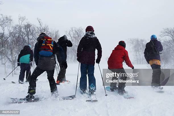 Skiers and snowboarders ride down a slope at the Niseko Hanazono resort, operated by Nihon Harmony Resorts KK, in Kutchan, Hokkaido, Japan, on...