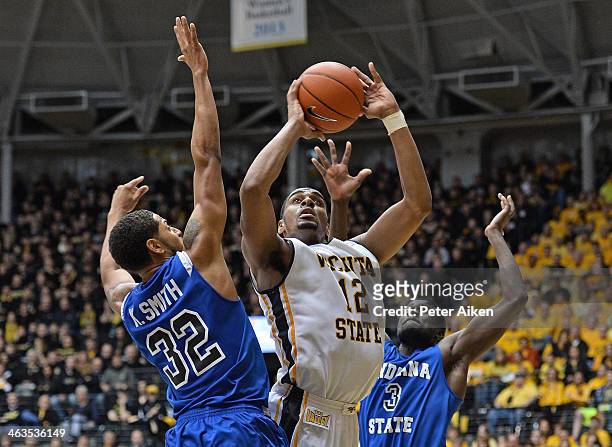 Forward Darius Carter of the Wichita State Shockers scores between defenders Manny Arop and Khristian Smith of the Indiana State Sycamores during the...