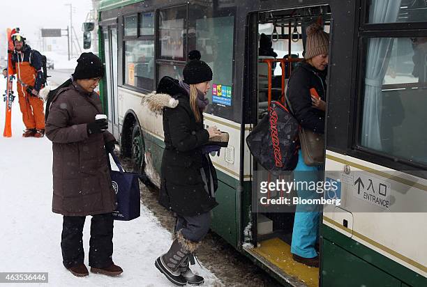 People board a bus in the Hirafu area of Kutchan, Hokkaido, Japan, on Saturday, Feb. 14, 2015. Japan had a record number of foreign visitors in 2014,...