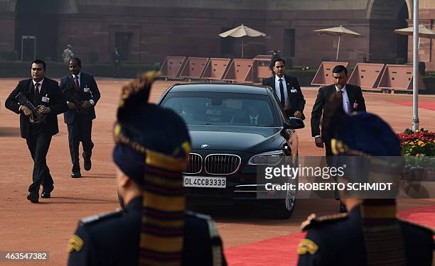 Bodyguards for Indian Prime Minister Narendra Modi run alongside his vehicle as he arrives at the Presidential Palace to attend the welcome ceremony...