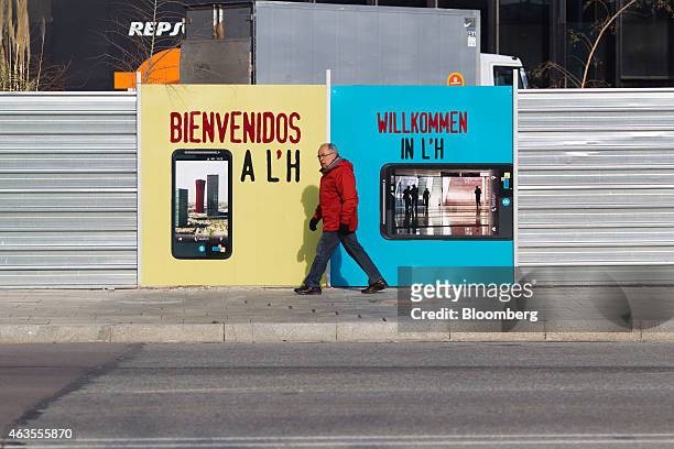 Pedestrian passes a mobile phone advertisement outside the Fira Gran Via venue for the Mobile World Congress in Barcelona, Spain, on Sunday, Feb. 24,...