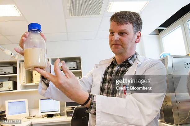 Hans Peter Smits, senior fermentation scientist for Evolva Holding SA, displays a bottle containing a yeast fermentation broth in a fermentation...