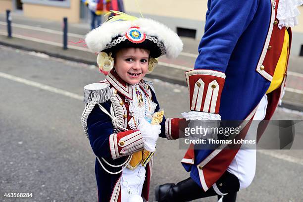 Young child walks with his father to the annual Rose Monday carnival parade on February 16, 2015 in Mainz, Germany. Rose Monday, in German called...