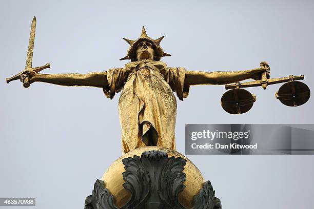 Statue of the scales of justice stands above the Old Bailey on February 16, 2015 in London, England.