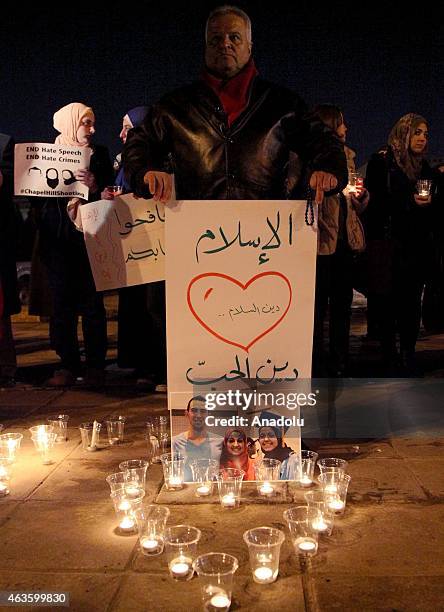 Candles are seen as a group of demonstrators gather in front of American Embassy in Amman to protest against the Chapel Hill shooting, in Amman,...